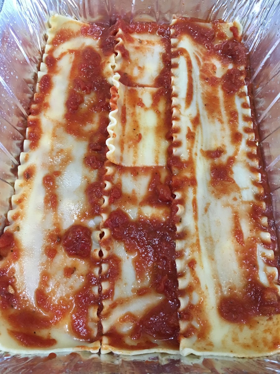 layering lasagna noodles with sauce