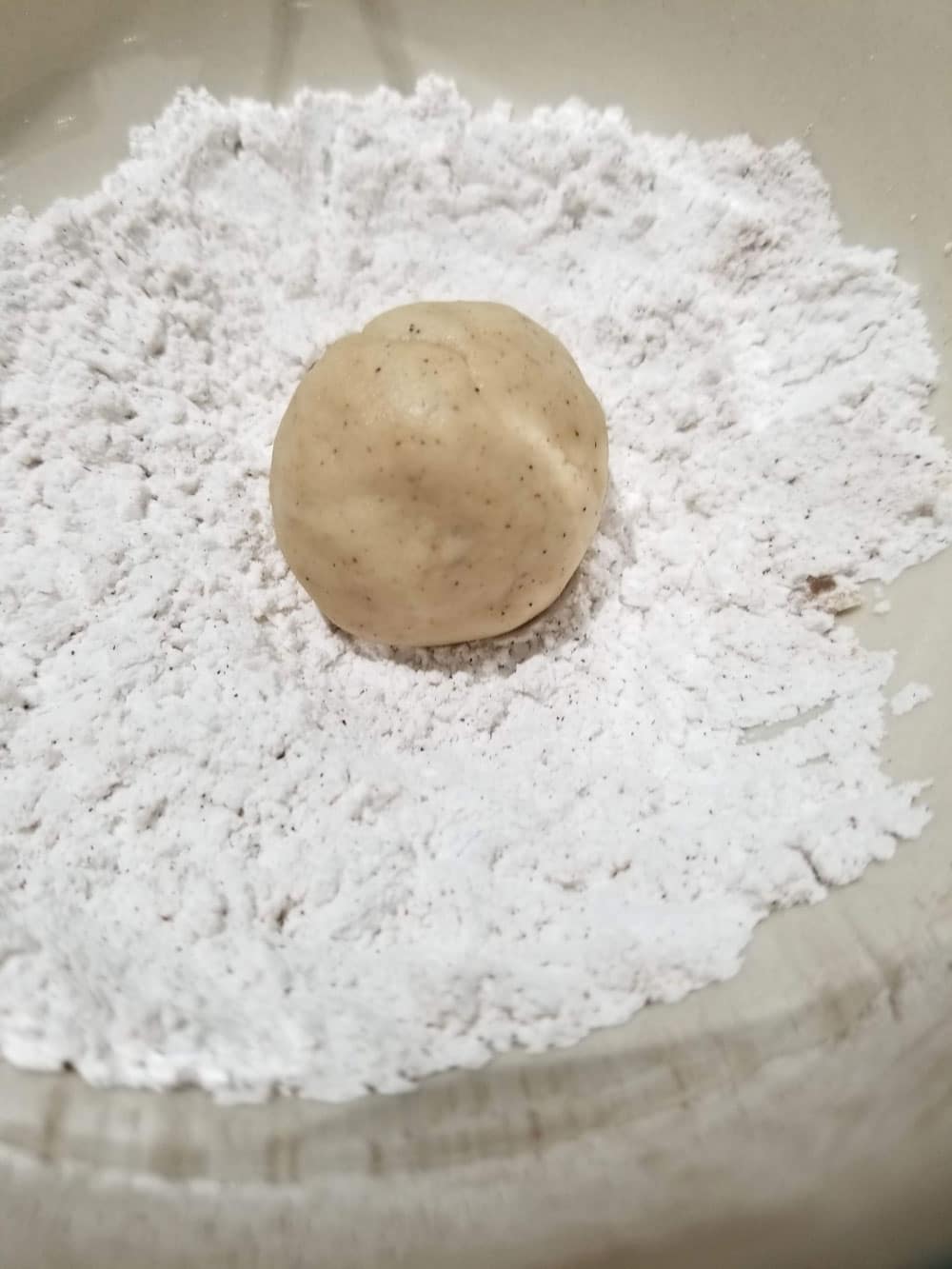 cookie dough ball in powdered sugar mix