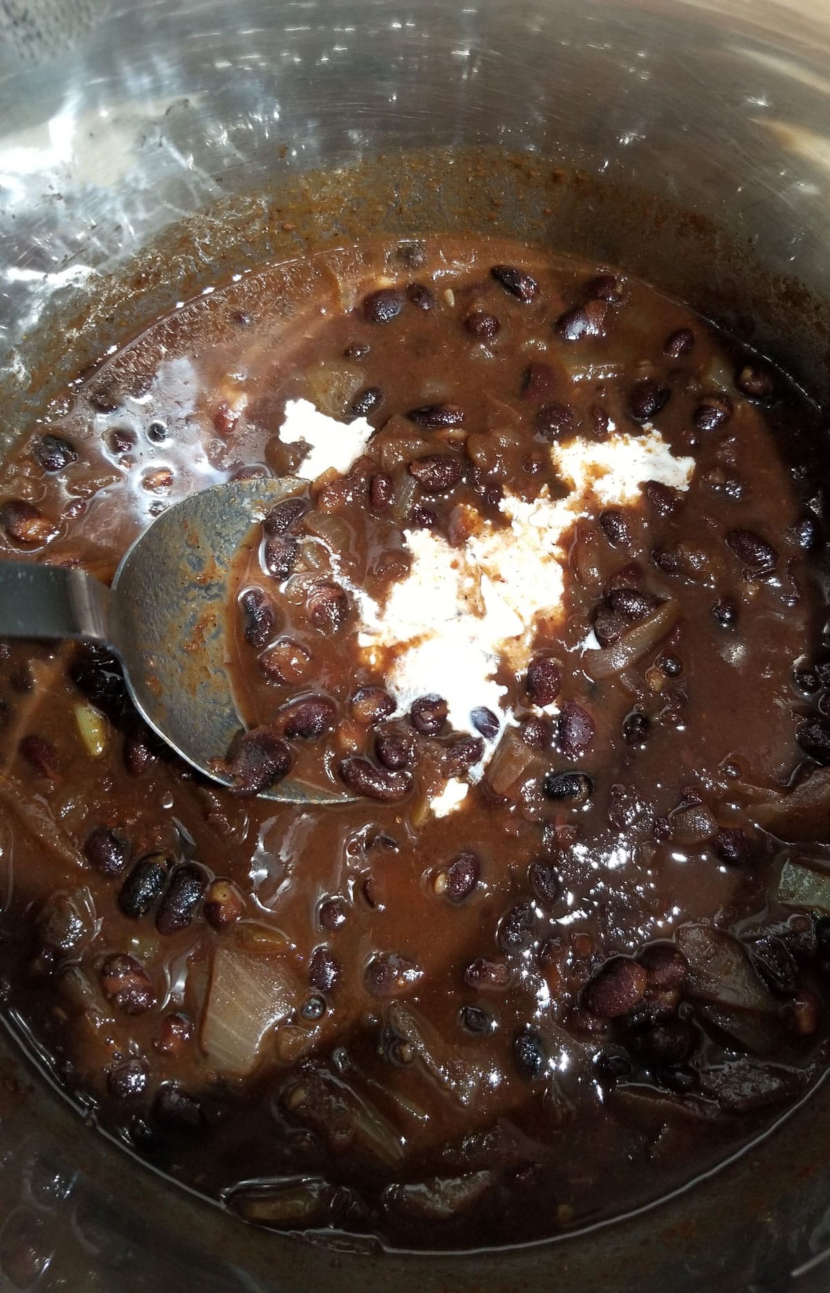 adding heavy cream to prepared black beans