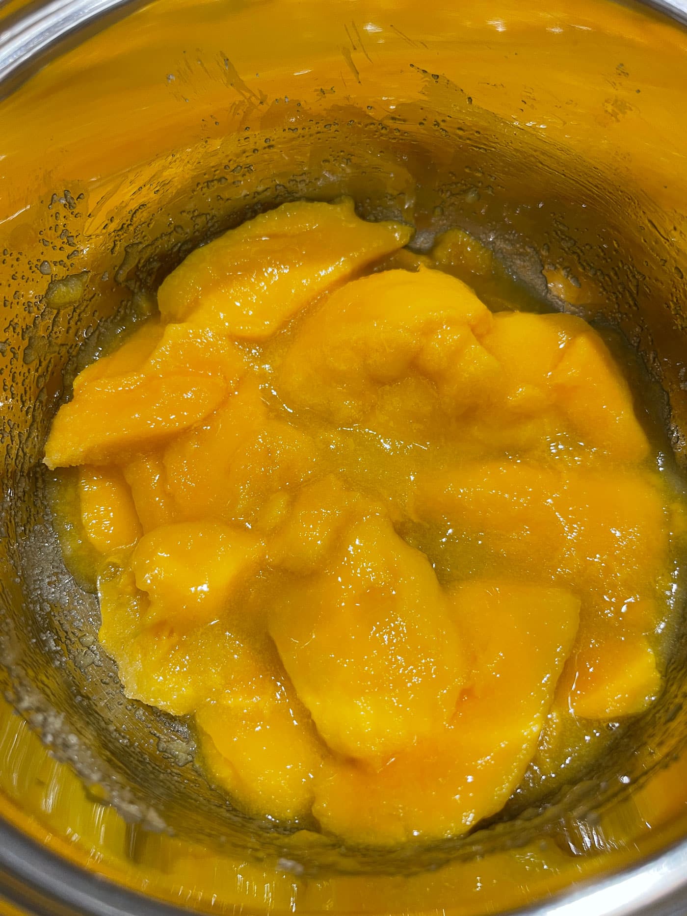 mangoes, sugar, lemon juice mixed together in saucepan