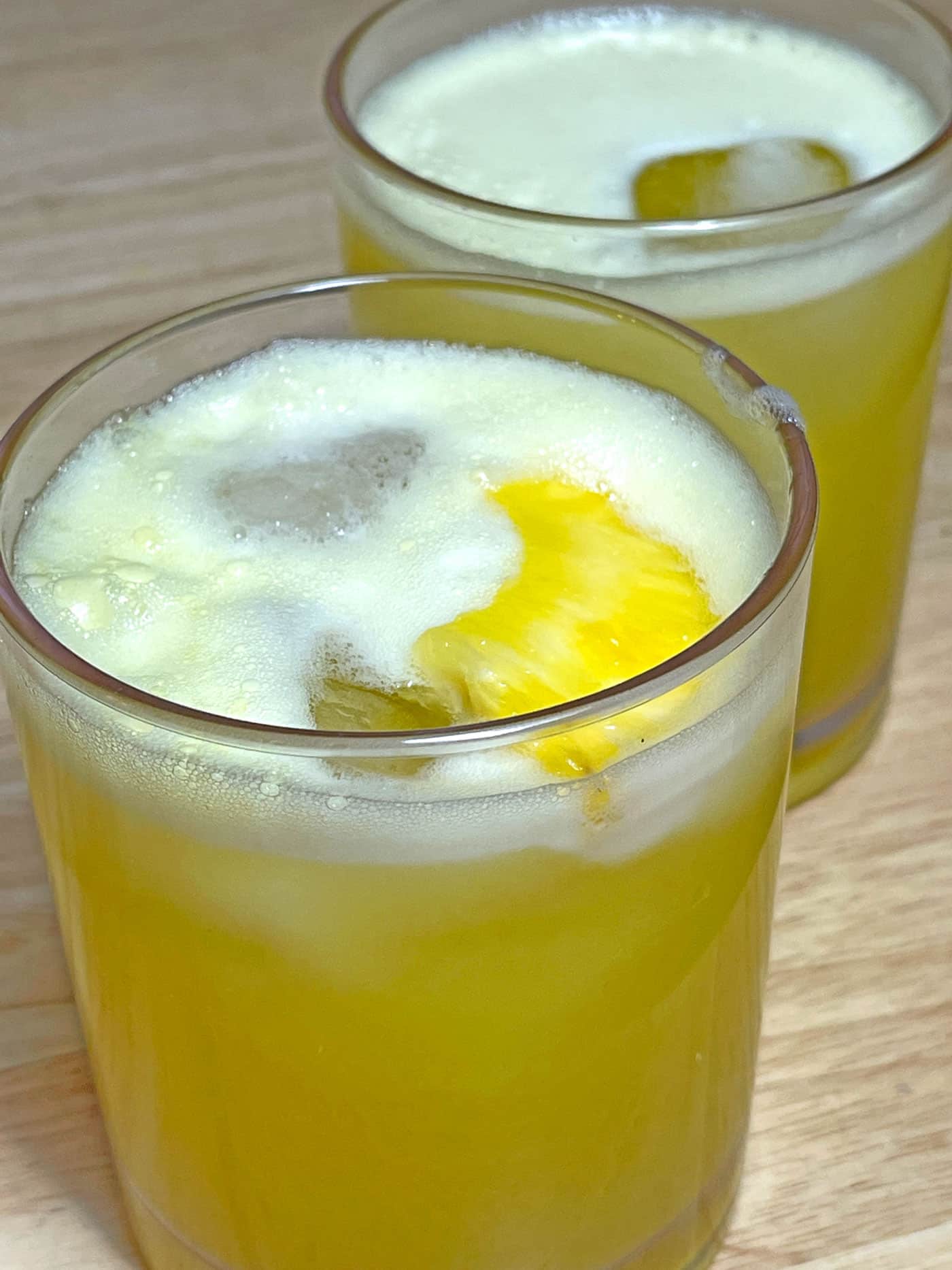 fresh pineapple juice garnished with pineapple wedges