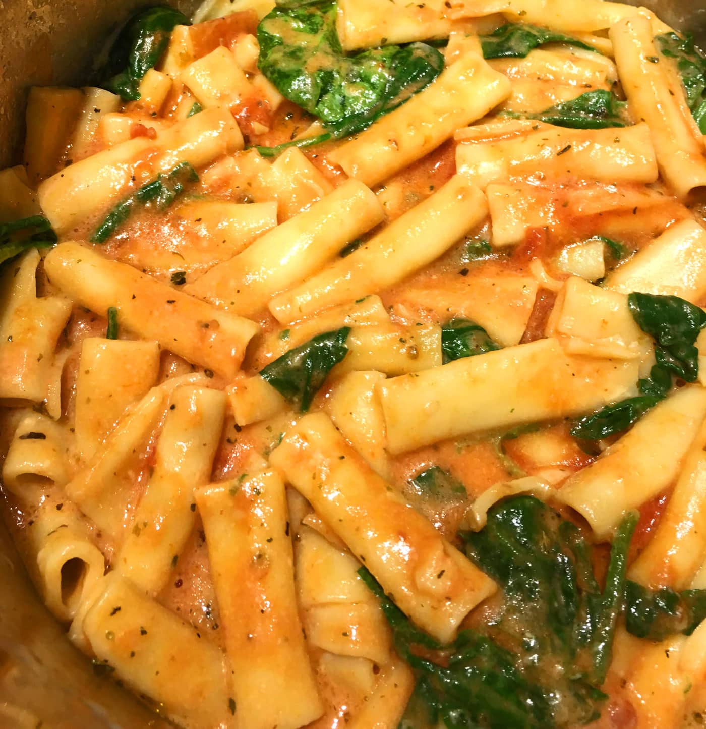 baked ziti pasta with spinach leaves