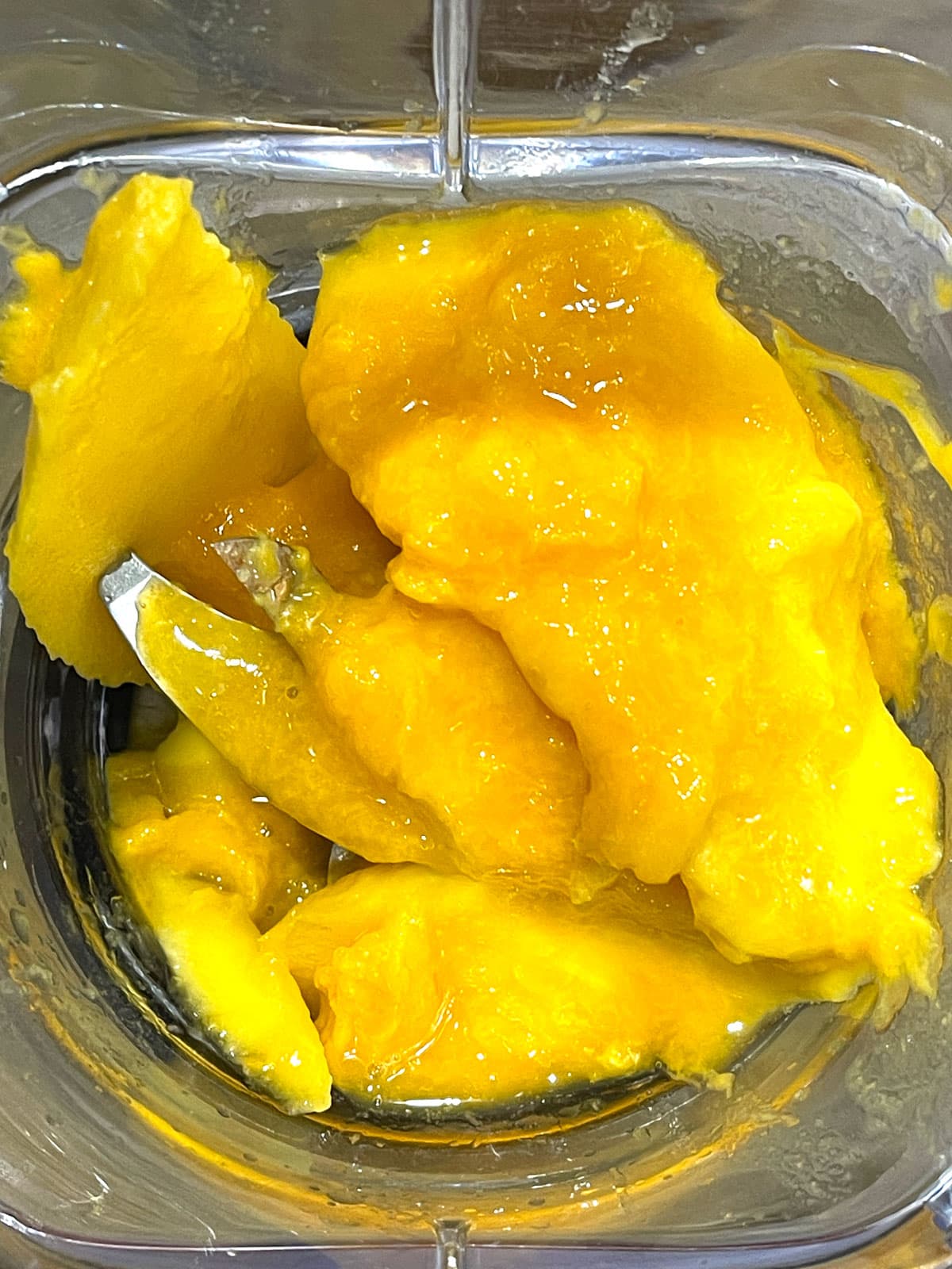 ripe mango slices in blender