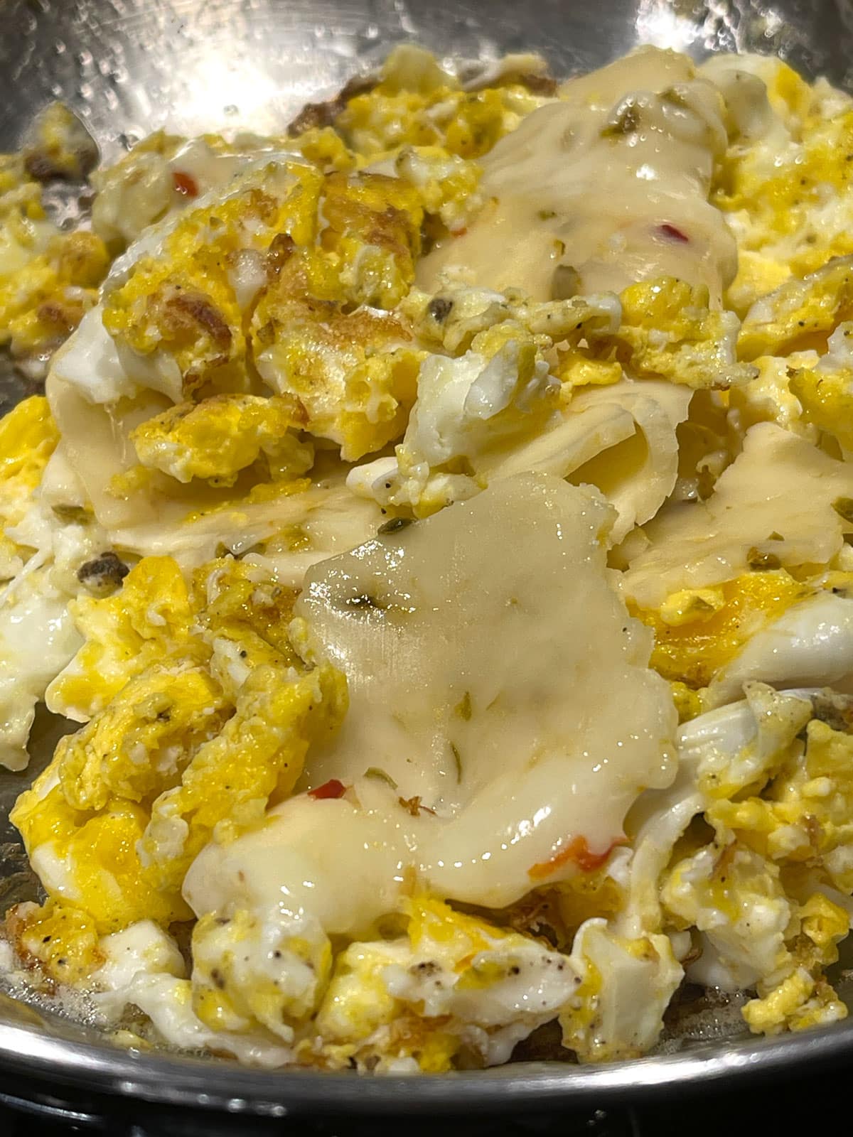 making cheesy scrambled eggs with pepper jack cheese slices